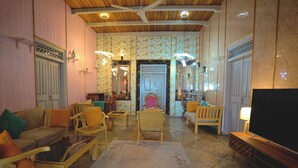 A spacious living area with a wooden ceiling, a large flat-screen TV, and a seating arrangement including a sofa and chairs. - Aura Beach Villa Deva 77 (Boossa)