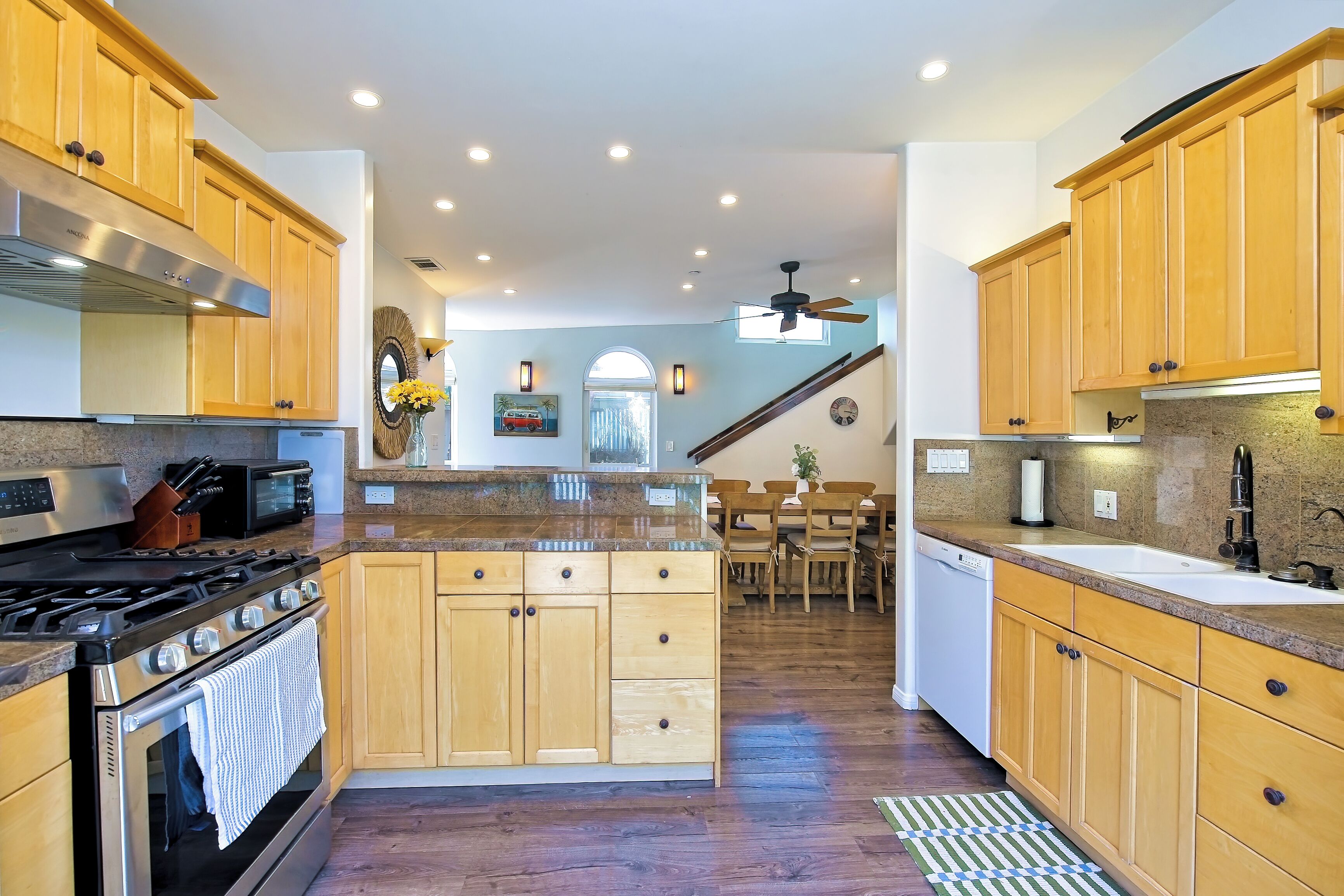 A modern kitchen with wooden cabinets, a built-in oven, and a gas stove.