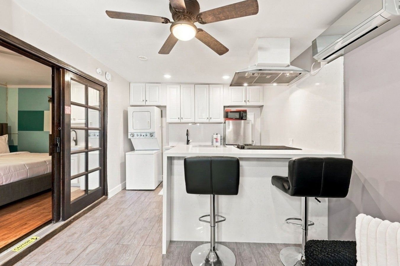 A compact kitchen with a central island, a ceiling fan, and a microwave.