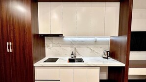 Una cocina compacta con estufa integrada, un lavamanos y una cafetera.