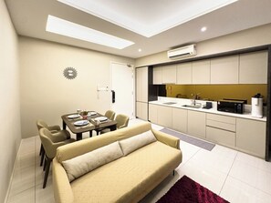 Un espacio habitable compacto con comedor, kitchenette y sofá.