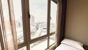 A hotel room with a large window, a bed, and curtains. - Dorsett Sri Hartamas by Airhost (Kuala Lumpur)