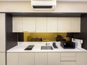 A modern kitchen with a built-in microwave, a sink, and a countertop. - Dorsett Sri Hartamas by Airhost (Kuala Lumpur)