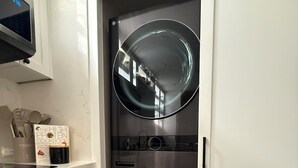 A compact kitchen with a microwave, utensils, and a cookbook on the counter. - Casa Oasis Boutique (Hermosillo)