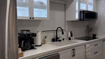 Una cocina moderna con electrodomésticos de acero inoxidable, lavavajillas y microondas.
