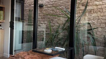 Una sala moderna con pared de piedra, una mesa de centro de vidrio y un sofá cómodo.