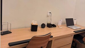 A modern office desk with a laptop, a tissue box, a pen holder, and a Newton's cradle. - Casa Oasis Boutique (Hermosillo)
