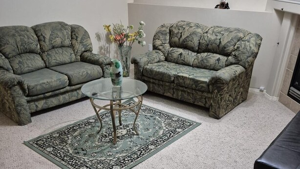 A living room with two camouflaged sofas, a glass coffee table, and a patterned rug. - 
Holiday Home in West Edmonton (Edmonton)