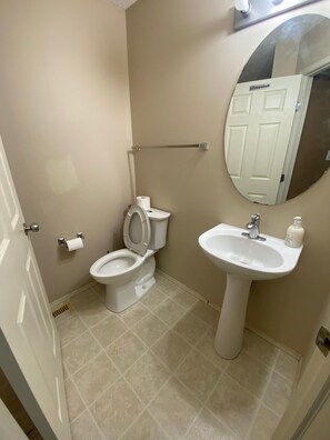 A bathroom with a toilet, sink, and mirror. - 
Holiday Home in West Edmonton (Edmonton)