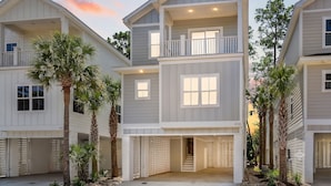 A multi-story residential building with a balcony on the upper floor, a garage, and a driveway. - Hang Ten House- 2.5 Blocks to Beach- Pet Friendly (Myrtle Beach)