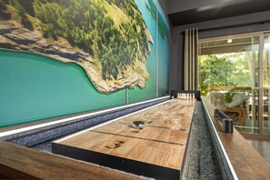 A pool table with a green wall mural, a window with a view of greenery, and a door with a glass panel. - Resort Cabin > Golf Cart! > Hot Tub > Lazy River > Indoor Pool > Shuffleboard (Hollister)