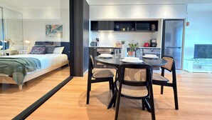 A modern bedroom with a bed, bedside tables, and a glass partition. - St Kilda Retreat with Office + City & Park Views! (St Kilda)