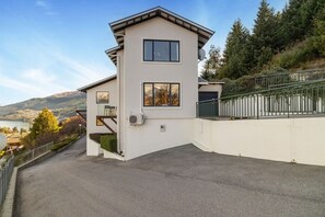 A modern two-story house with a balcony, a satellite dish, and a view of a lake and mountains. - Jaw Dropping Views, Close To The Heart Of Queenstown (Queenstown)