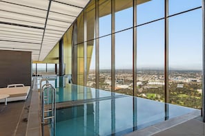 Ein moderner Innenpool mit Infinity-Kante und freiem Blick auf die Stadtlandschaft.