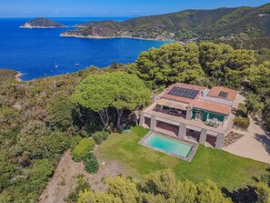 A coastal property with a swimming pool, solar panels, and a view of the sea. - Charming Villa with a Pool and a View of the Gulf of Procchio. (Procchio)