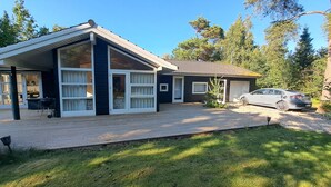 Et toetagers hus med en overdækket veranda, en garage og en bil parkeret i indkørslen.