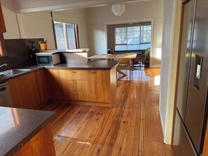 A modern kitchen with wooden cabinets, a granite countertop, and a stainless steel refrigerator. - Newport House 2 bedroom, 1 sofa bed, 1 bathroom (Newport)