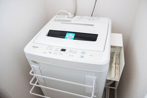 Un dispositivo blanco, compacto y multifuncional con pantalla y varios botones, probablemente una impresora o escáner portátil, sobre una superficie blanca.