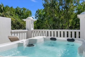 A hot tub with a white exterior, surrounded by a white fence, and trees in the background. - 3434 Peppers Spa Penthouse (Palm Cove)