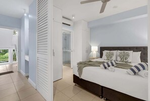 A bedroom with a bed, bedside lamps, and a view of a balcony. - 3434 Peppers Spa Penthouse (Palm Cove)