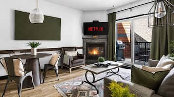 A modern living room with a fireplace, a television, and a dining area.