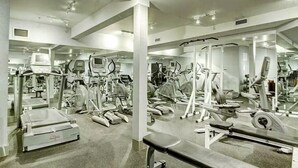 A gym with various exercise equipment, including treadmills, stationary bikes, and weight machines. - Chic Twin Rockies Getaway - Pool&HotTub | Sleeps 8 (Canmore)