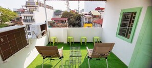 A small balcony with two chairs, a table, and a green artificial turf floor. - Group Stay for 4 • Big Beds • Hanoi Old Quarter Centre • Locker • Free Wash (Hà Nội)