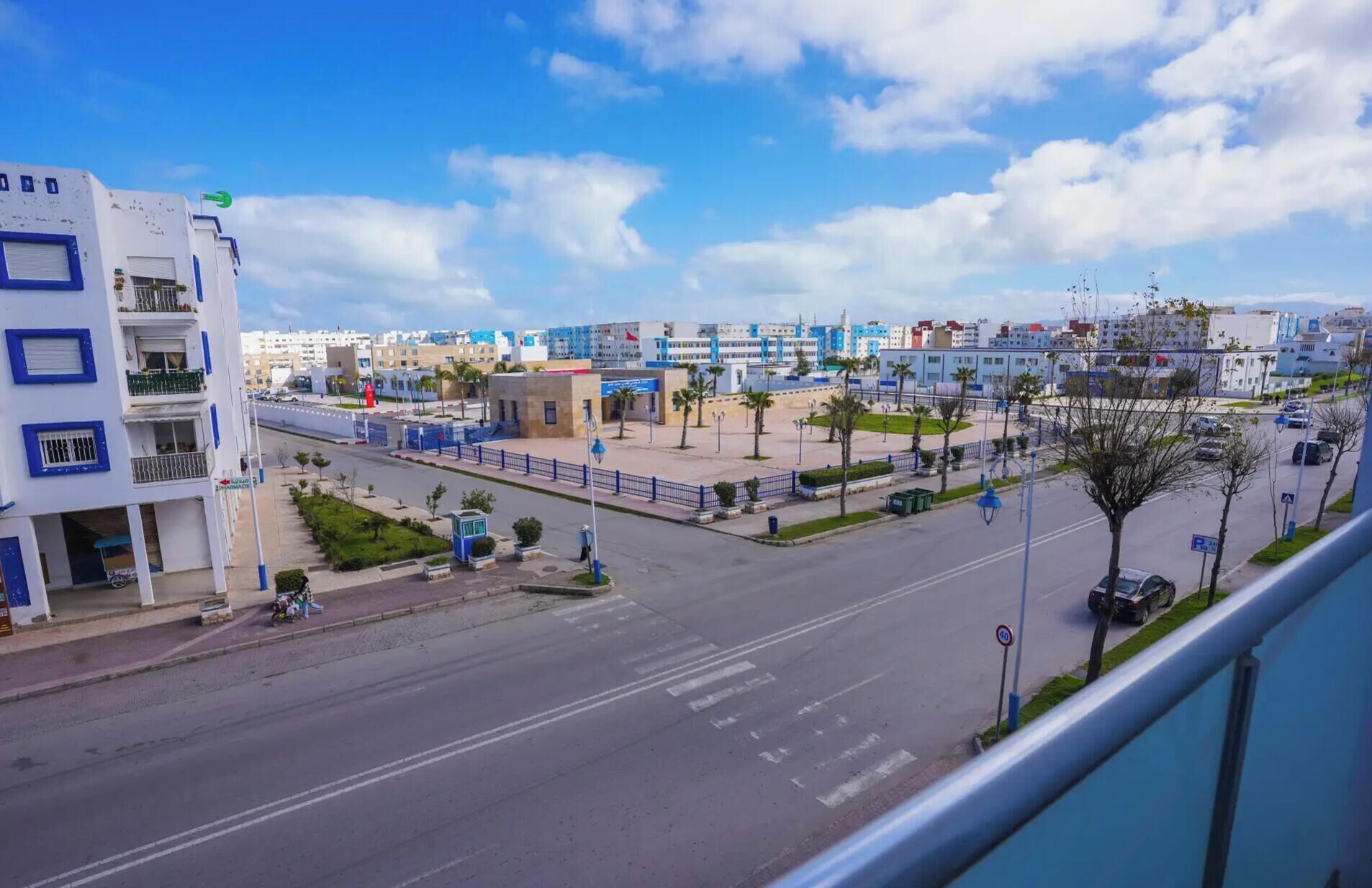 A street view with buildings, a pedestrian crossing, and a clear sky.