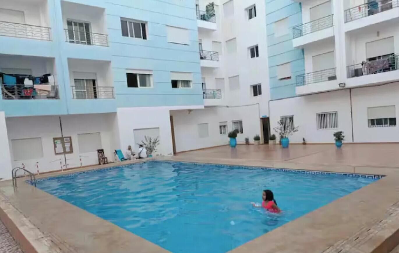 A swimming pool surrounded by multi-story residential buildings with balconies.