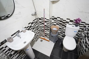 A bathroom with a white sink, toilet, and a shower area. - Charming 2 -bedroom Apartment in Martil, Morocco (Martil)