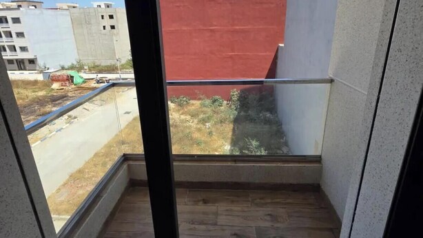 Ein Balkon mit Blick auf eine Baustelle und Gebäude im Hintergrund.