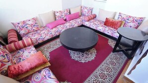 A corner seating area with a sofa set, a round coffee table, and a small table. - Charming 1-bedroom Apartment With Piscine in Martil (Martil)