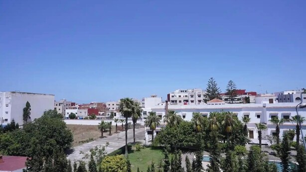 Um bairro residencial com edifícios brancos, céu claro e áreas verdes.
