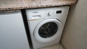 En tvättmaskin från Whirlpool i ett kök med en bänkskiva i granit.