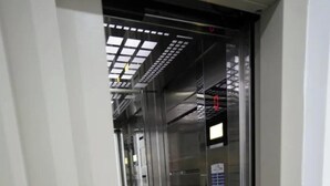 En hissinredning med väggar i metall, en manöverpanel och en digital display.