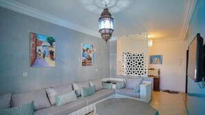 A living room with a sofa, a round coffee table, and a decorative lantern. - Charming 2-bedroom Apartment in Martil, Morocco (Martil)