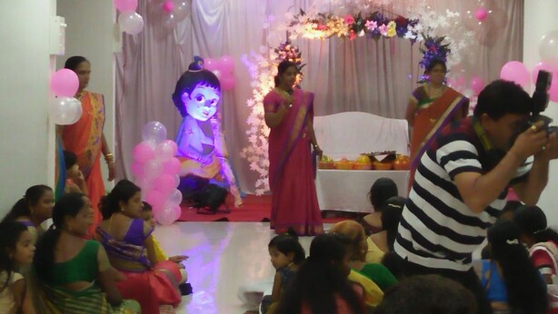 A room with a stage, audience seating, and a photographer. - Hotel Rama Palace (Nashik)