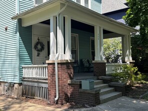 Une maison avec un porche, des marches et des fondations en briques.