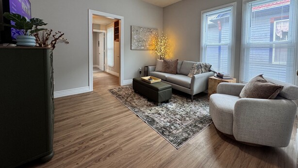 A living room with a ceiling fan, a sofa, a coffee table, and a side chair. - Central Location | Park Views | Fiber WIFI (Bloomington)