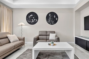 Ein stilvolles Wohnzimmer mit zwei Sofas, einem Couchtisch und Wandbildern.