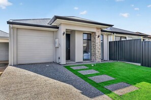 A modern residential house with a garage, a covered outdoor area, and a well-maintained lawn. - Leeds House | 4BR New Build, Alfresco, 15 Min CBD (Northfield)