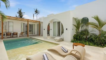 A modern outdoor pool area with lounge chairs and a dining setup.