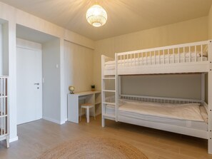 A bunk bed room with a desk and chair, a globe, and a door. - A beautifully renovated flat on the Zeedijk (Blankenberge)