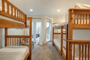 Una habitación con literas, una escalera y una puerta que da al exterior.