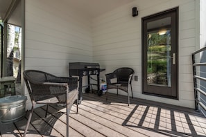 A covered patio with two wicker chairs, a grill, and a trash can. - Modern Lower Deer Valley 3 Bed / 3.5 Bath, Walk to Main Street – A/C (Park City)