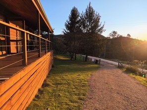 A wooden building with a covered porch and a gravel path leading to a road.