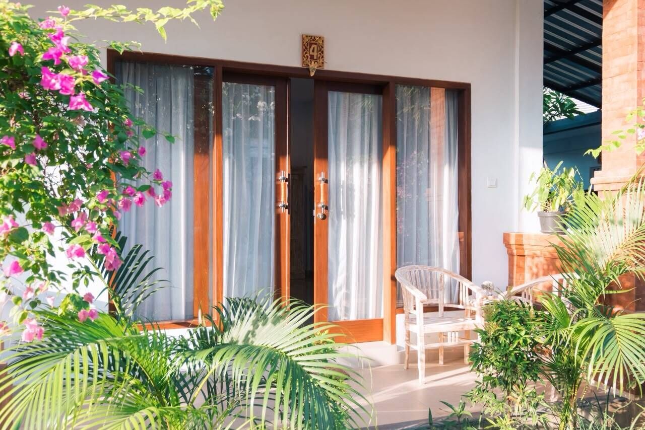 A room with a sliding glass door, a white chair, and a small table.