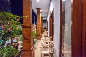 A corridor with columns, chairs, and potted plants. - The Lonceng Canggu (Canggu)