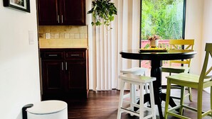 Una cocina moderna con alacenas de madera oscura, una encimera blanca y una planta colgante.