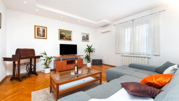 A modern living room with a sofa, a coffee table, a television, and decorative items. - Perfect 2-bedroom apartment with AC in beautiful Rovinj (Rovinj)